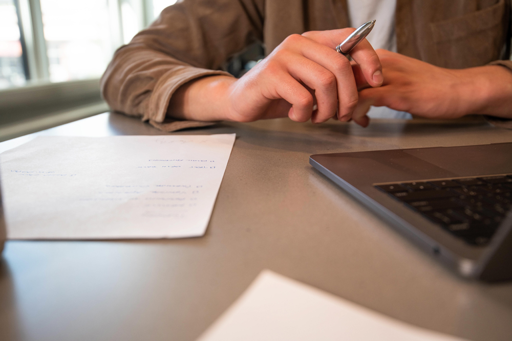 Taking notes with laptop on table